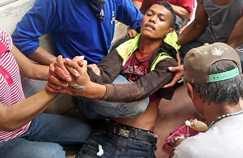 A farmer wounded in the violent dispersal in Kidapawan City is helped by his fellow protesters. Image: Interaksyon/Kilab Multimedia