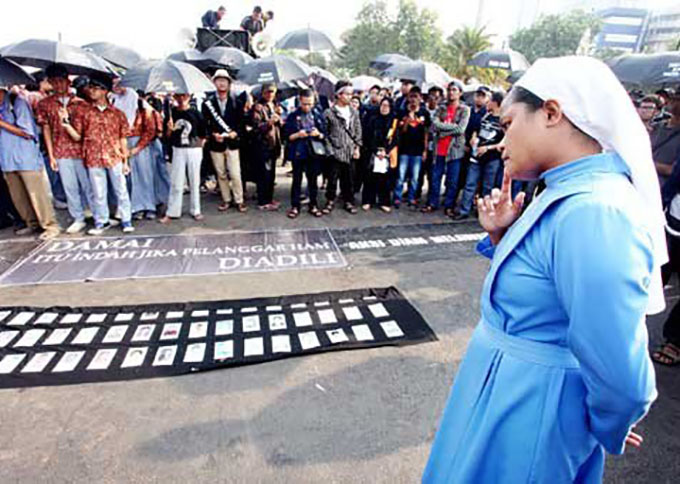 A nun observes photographs of victims of past human rights abuses in front of the State Palace in Jakarta during a weekly rally that is locally known as Kamisan. This rally was the 417th since 2007 and it demanded demanding the government resolve the cases. (Seto Wardhana )