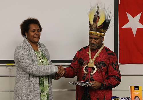 AUT doctoral student Stephanie Sageo-Tupungu of Papua New Guinea makes a presentation to Benny Wenda on behalf of the Pacific Media Centre. Image: Kendall Hutt/PMC