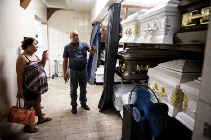 Philippines "war on drugs": Veronica Memorial Chapel Funeral director Rico Teodocio (second from left) talking to a relative of an alleged drug dealer who was killed by unidentified men about the prices of various coffins in Manila. Image: Noel Celis/AFP/Rappler