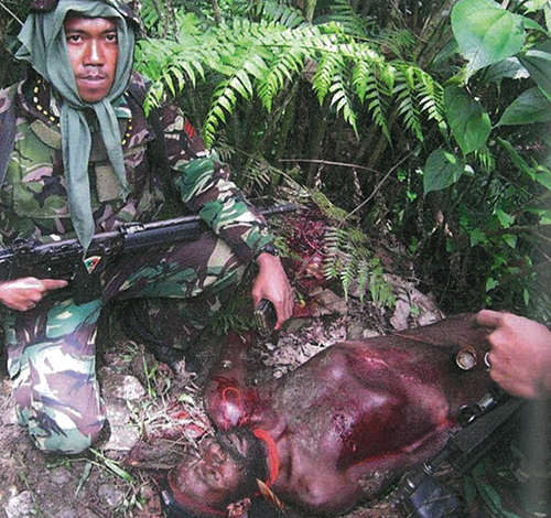 A “trophy photo” by an Indonesian soldier from Battalion 753 of a man he had shot from the Lani tribe in 2010. Image from Papua Blood