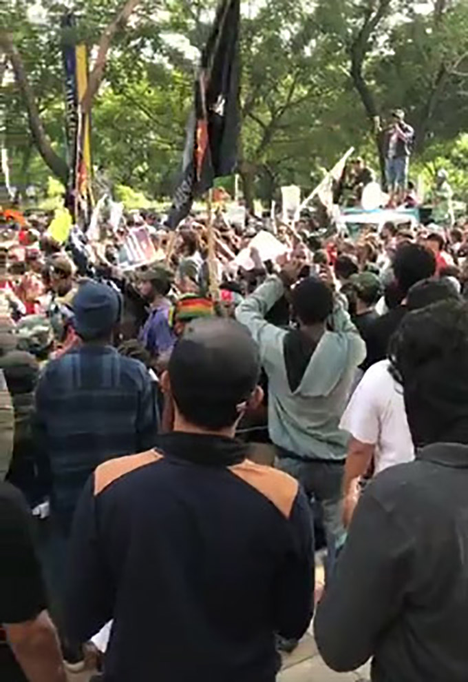 A scene from the Surabaya rally today with the crowd chanting “Freedom Papua”. The men in the front of the image appear to be undercover police filming and recording events. A short distance away there was a counterprotest with Indonesian flags. Police kept the two groups apart. Image: Still from a West Papuan sourced video