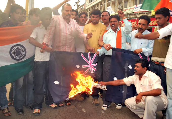 Protesters burn an Australian flag