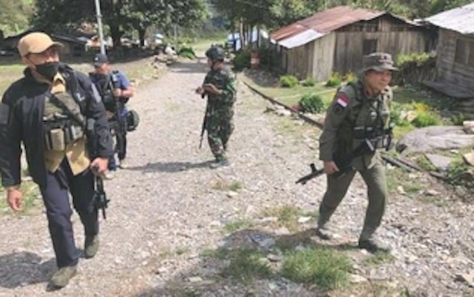 Indonesian soldiers patrol a Papuan village