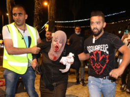 People helping an injured Palestinian woman