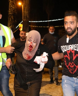 People helping an injured Palestinian woman