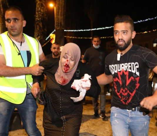People helping an injured Palestinian woman