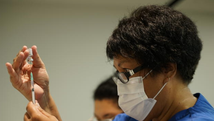 A NZ vaccinator prepares a covid-19 vaccination