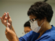 A NZ vaccinator prepares a covid-19 vaccination