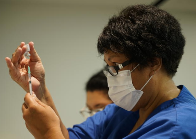 A NZ vaccinator prepares a covid-19 vaccination