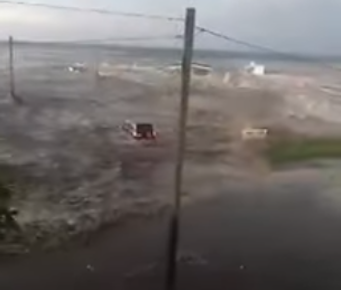 A vehicle being swept away by the tsunami wave on 'Eua 