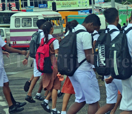 Fiji students walk to a secondary school in Suva