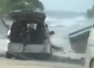 Motorists try to flee a tsunami wave on the foreshore in the Tongan capital of Nuku'alofa