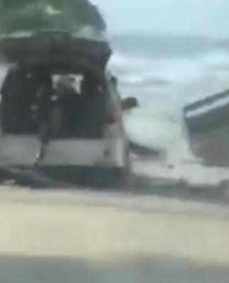 Motorists try to flee a tsunami wave on the foreshore in the Tongan capital of Nuku'alofa