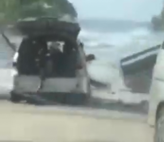Motorists try to flee a tsunami wave on the foreshore in the Tongan capital of Nuku'alofa