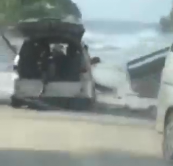 Motorists try to flee a tsunami wave on the foreshore in the Tongan capital of Nuku'alofa