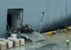 Workers load the HMAS Adelaide with supplies for Tonga