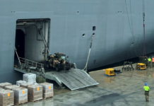 Workers load the HMAS Adelaide with supplies for Tonga