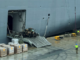 Workers load the HMAS Adelaide with supplies for Tonga