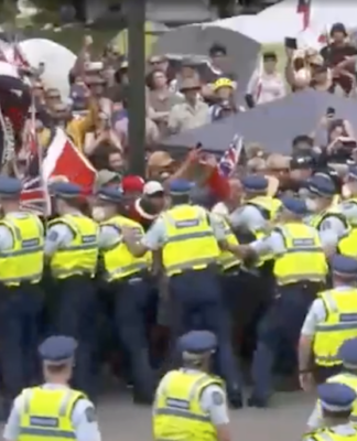 Anti-vaxxer protesters try to break through a police barrier on New Zealand's Parliament grounds