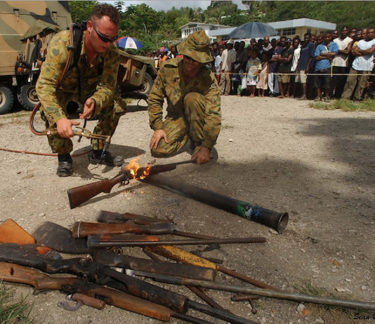 Members of RAMSI military destroy surrendered weapons