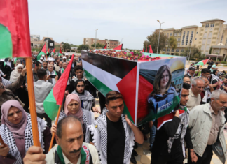 Students carry a mock coffin as they hold a symbolic funeral for slain Al Jazeera journalist Shireen Abu Akleh