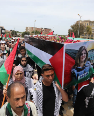 Students carry a mock coffin as they hold a symbolic funeral for slain Al Jazeera journalist Shireen Abu Akleh