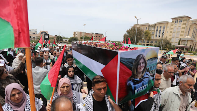 Students carry a mock coffin as they hold a symbolic funeral for slain Al Jazeera journalist Shireen Abu Akleh