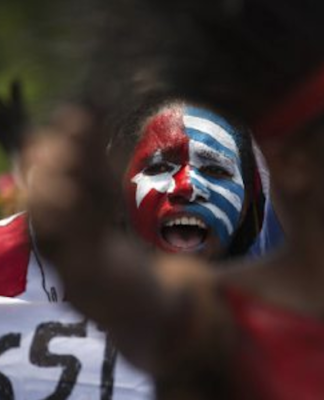 Papuan students, with their body and face painted with the colours of the banned Morning Star flag