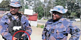 PNG police officers with a gun allegedly seized from an election candidate
