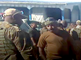 Papua New Guinean police question a PNGDF soldier stationed at Pares