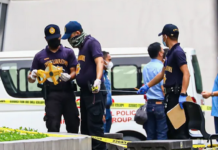 Philippine police inspect the assassination crime scene at the Ateneo de Manila University
