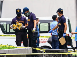 Philippine police inspect the assassination crime scene at the Ateneo de Manila University