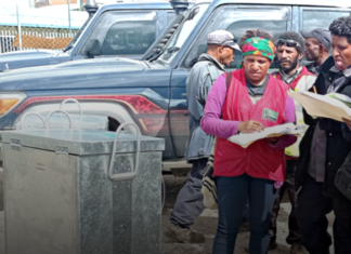 Polling officials check details from two ballot boxes arriving in Tari