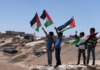 Palestinian children wave the national flags at the West Bank village of Masafer Yatta