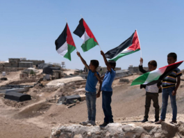 Palestinian children wave the national flags at the West Bank village of Masafer Yatta