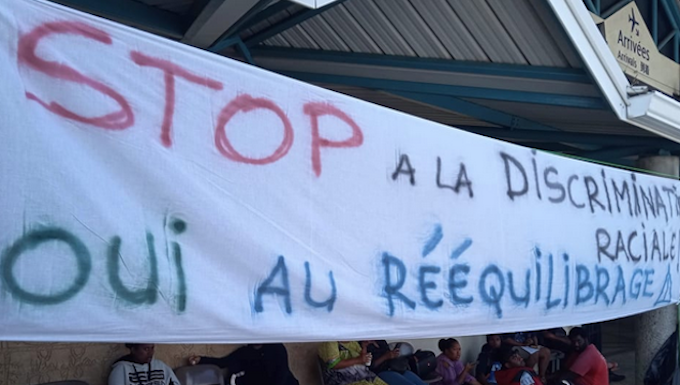 A "stop racial discrimination" banner at Magenta-Noumea Airport