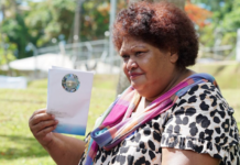 Asinate Colovanua fans herself with the FEO voter booklet