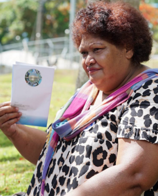 Asinate Colovanua fans herself with the FEO voter booklet