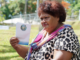 Asinate Colovanua fans herself with the FEO voter booklet