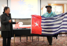 Hilda Halkyard-Harawira and Ronny Ato Buai Kareni with the Morning Star flag at the Nuclear Connections Across Oceania conference in Ōtepoti