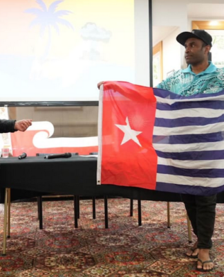 Hilda Halkyard-Harawira and Ronny Ato Buai Kareni with the Morning Star flag at the Nuclear Connections Across Oceania conference in Ōtepoti