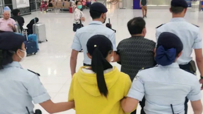 Republic of the Marshall Islands citizens Cary Yan and Gina Zhou being escorted by Thai police