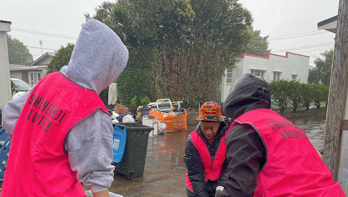 Volunteers help residents in Auckland's Mt Roskill to clear up after the flash floods hit the city last weekend