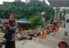 A woman in Jayapura stands next to a collapsed wall after the quake