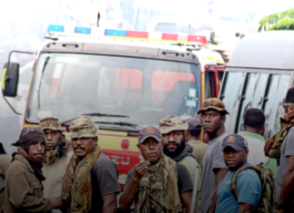 PNG Defence Force soldiers keep watch after running riot in the Port Moresby suburb of Boroko
