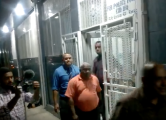 Suspended Police Commissioner Sitiveni Qiliho (right in shadows walking outside Suva's CID headquarters)