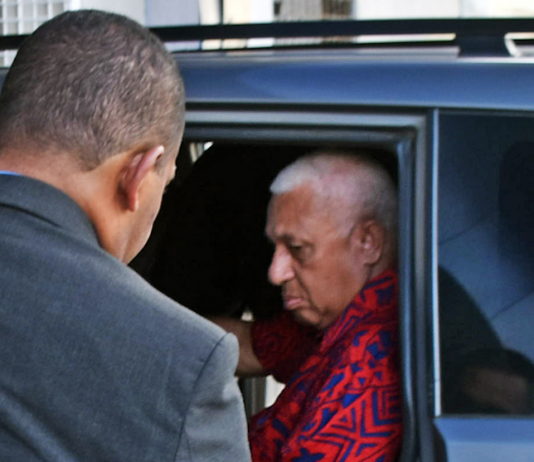 Former Fiji prime minister Voreqe Bainimarama arrives at the Police CID headquarters in Suva last night before being charged and held at Totogo Police Station
