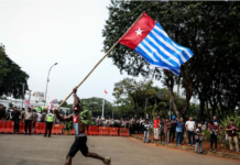 A lone protester raises the Morning Star flag of West Papua