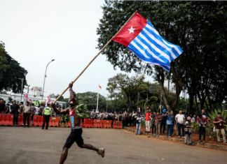 A lone protester raises the Morning Star flag of West Papua